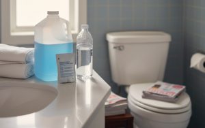 Préparation pour une coloscopie avec des produits et une bouteille d'eau dans une salle de bain.